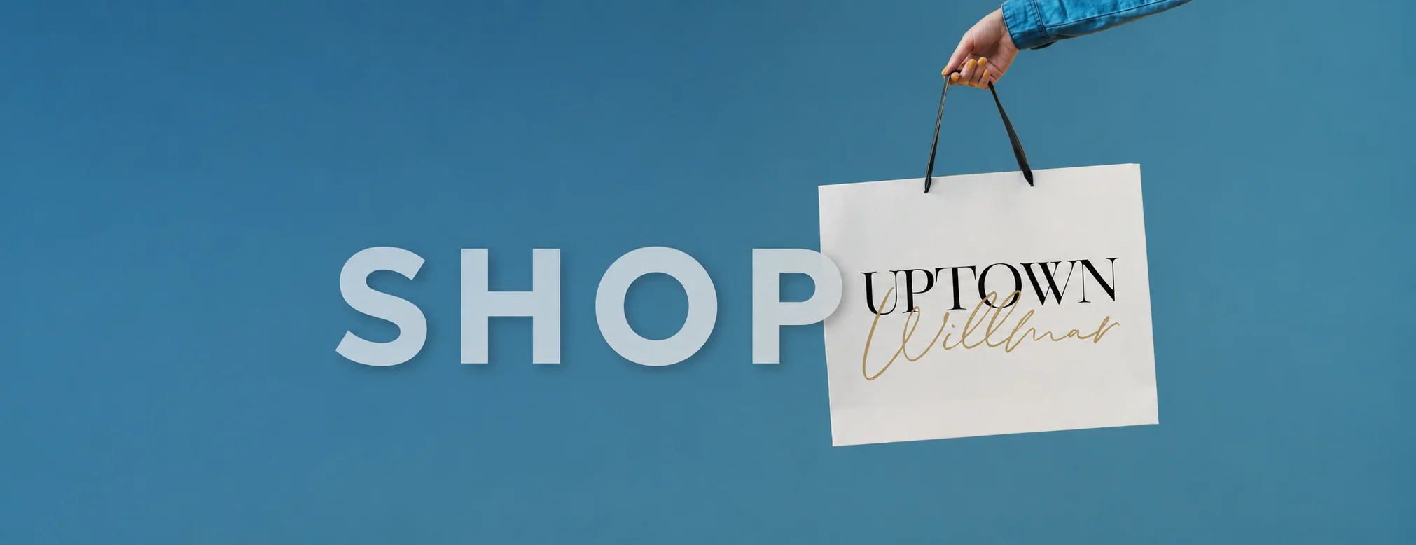 Shop Uptown Willmar: a hand holding an Uptown Willmar shopping bag